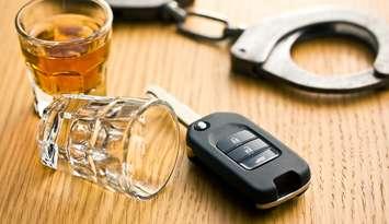 Alcohol, keys and police handcuffs depicting drinking and driving.  © Can Stock Photo / jirkaejc